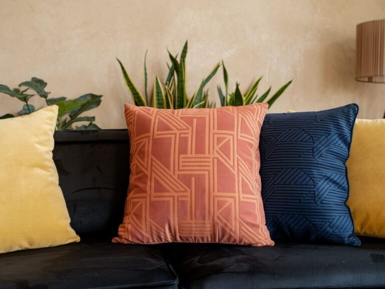 Kanapa w czarnym kolorze z poduszkami o różnorodnych teksturach