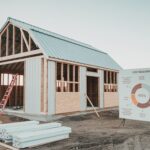 Mały budynek gospodarczy z dachem spadzistym otoczony ogrodem