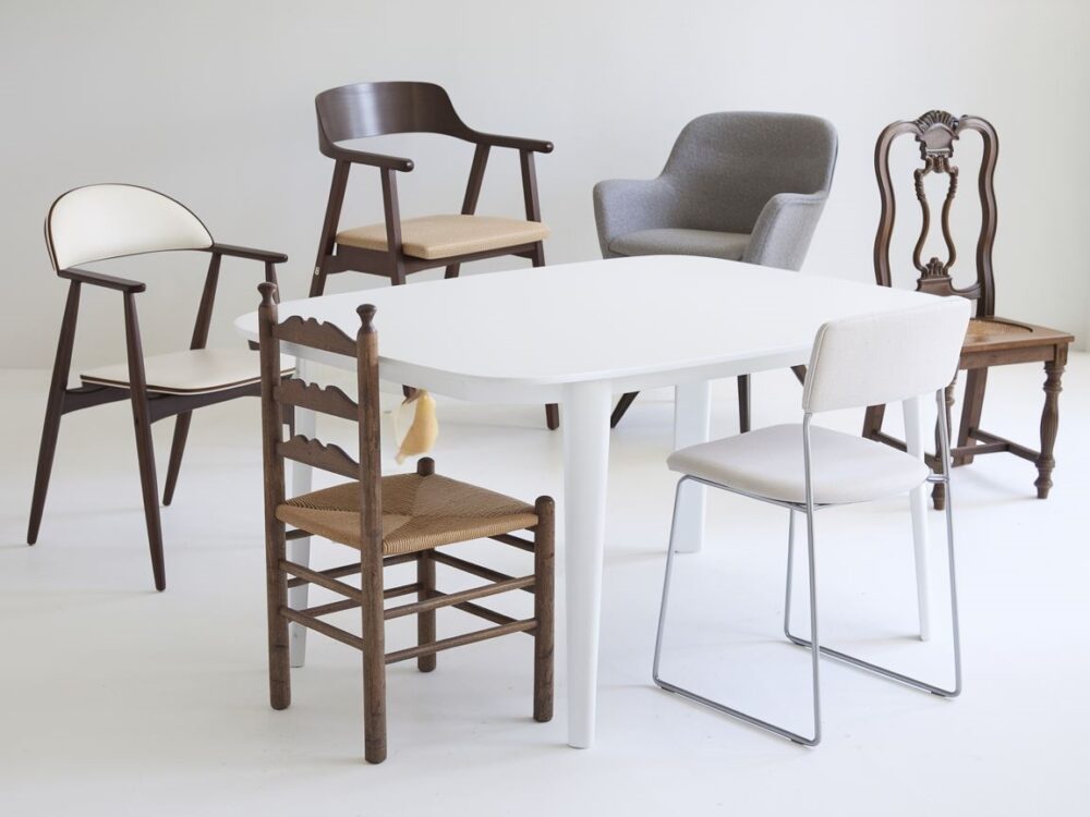 Transparentne krzesła przy białym stole w minimalistycznej aranżacji